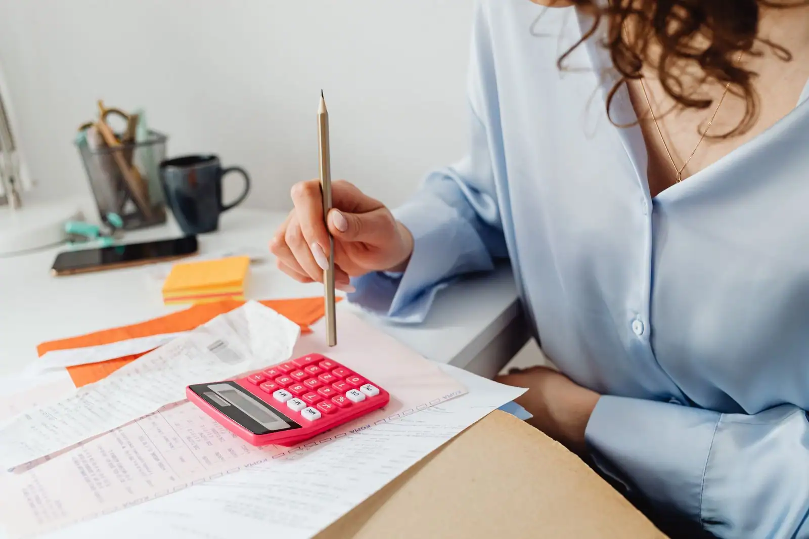 Auto-entrepreneur préparant sa déclaration d'impôts avec une calculatrice et des documents administratifs