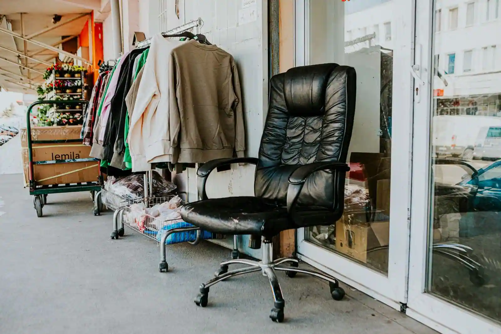 Portant de vêtements d'occasion exposés devant une boutique de seconde main