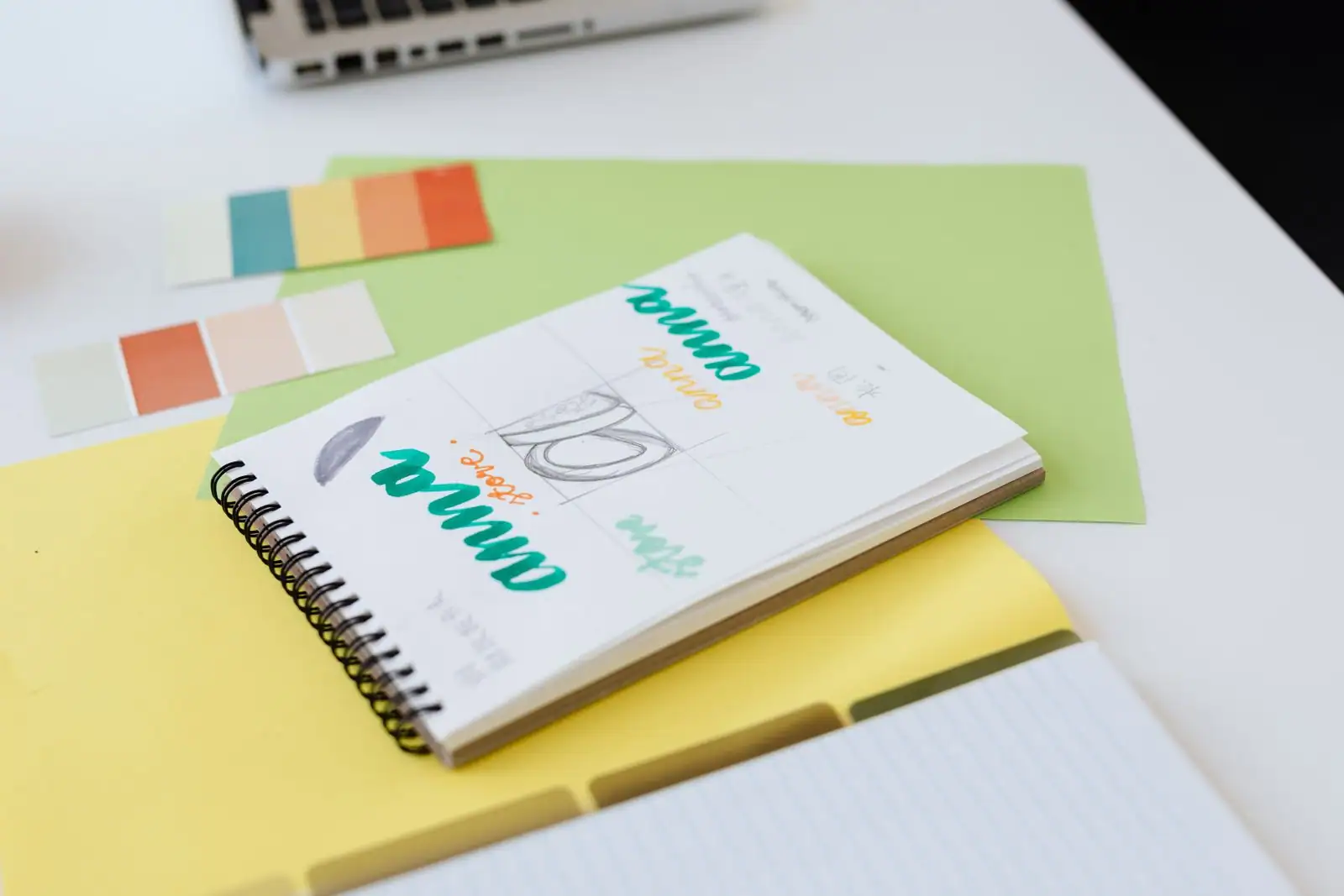 Plan de travail de designer avec nuancier de couleurs, croquis et échantillons d'identité graphique