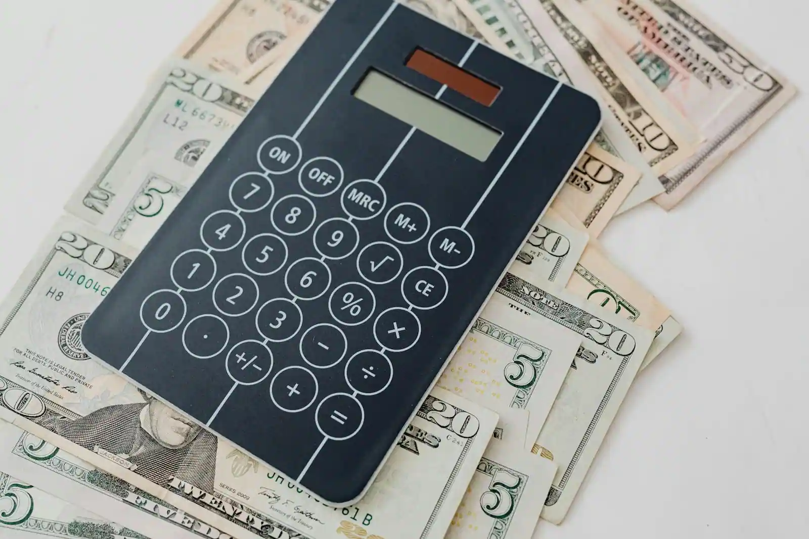 Billets de dollars américains et d'euros posés près d'une calculatrice, illustrant la conversion de devises.