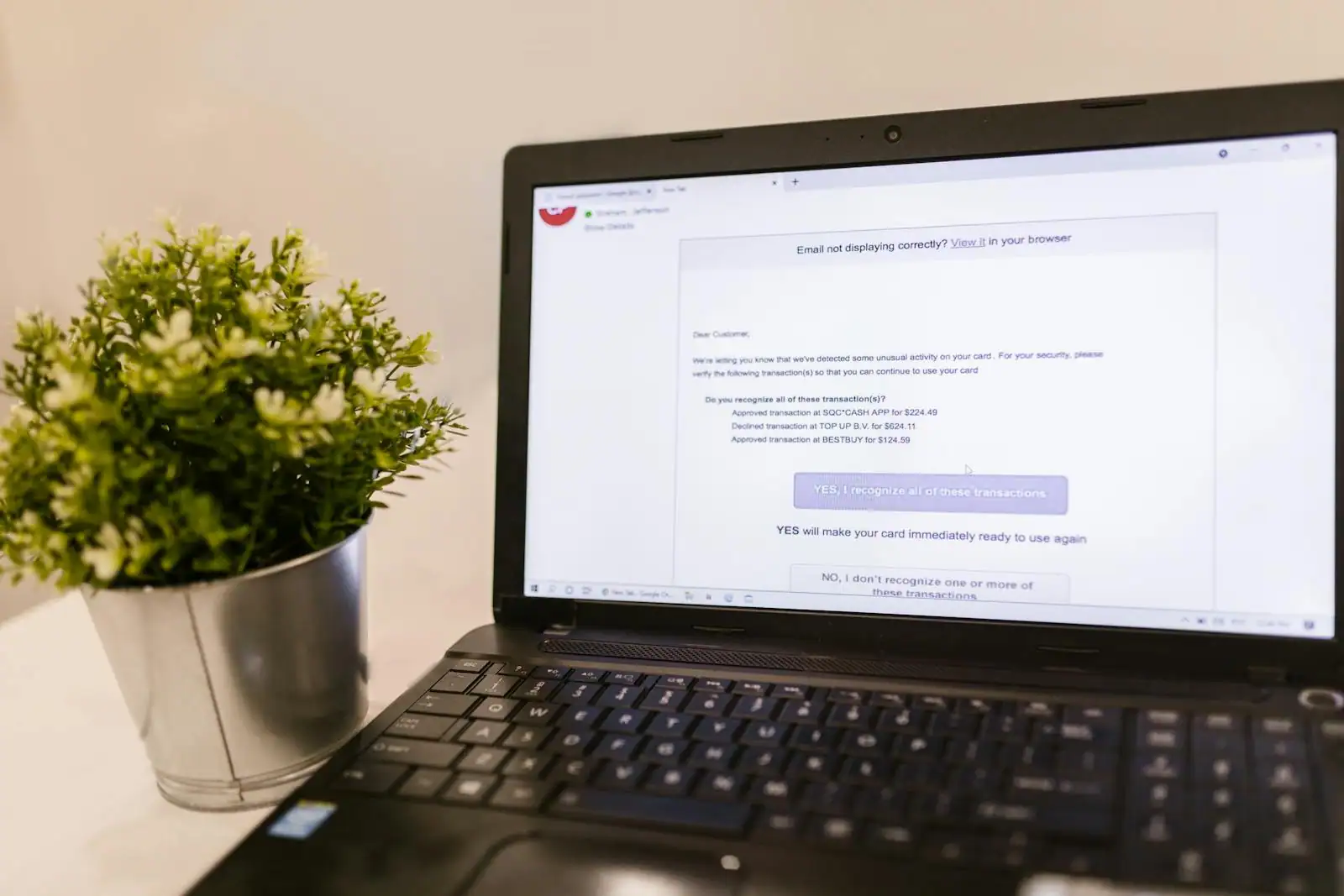 Ordinateur portable ouvert sur une interface de messagerie e-mail posé sur un bureau clair et ordonné