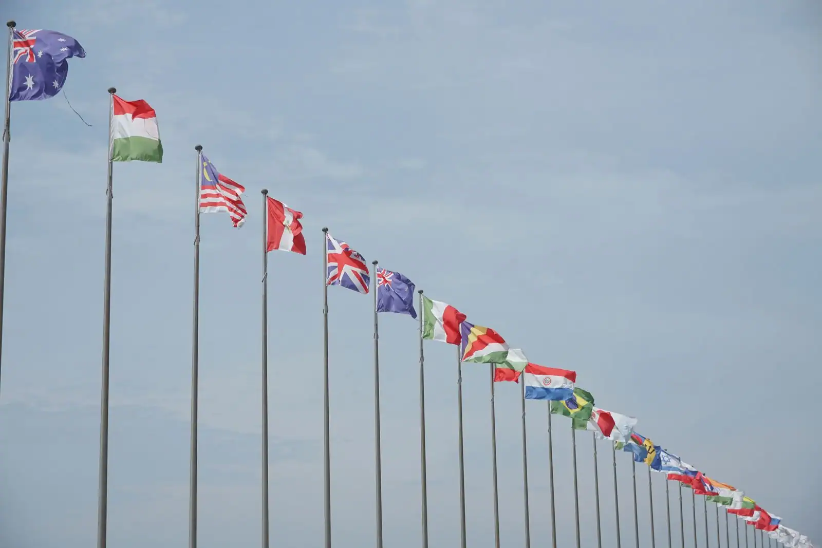 Rangée de drapeaux nationaux flottant côte à côte, évoquant la coopération internationale