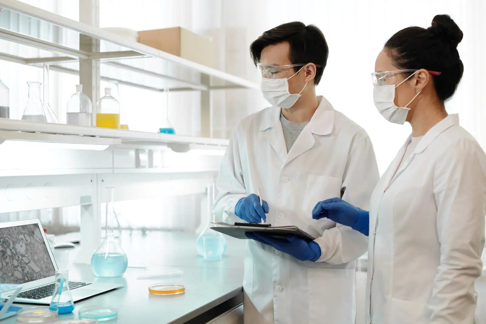 Chercheurs au travail dans un laboratoire moderne, parmi des équipements scientifiques.