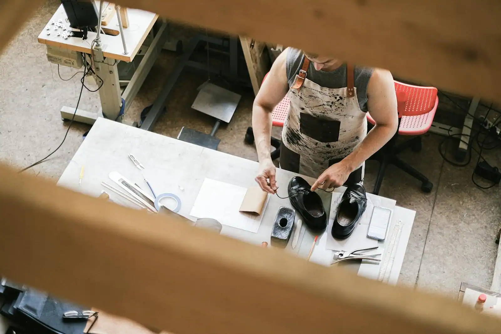 Établi d'un bottier artisan avec outils de cordonnerie, formes en bois et pièces de cuir