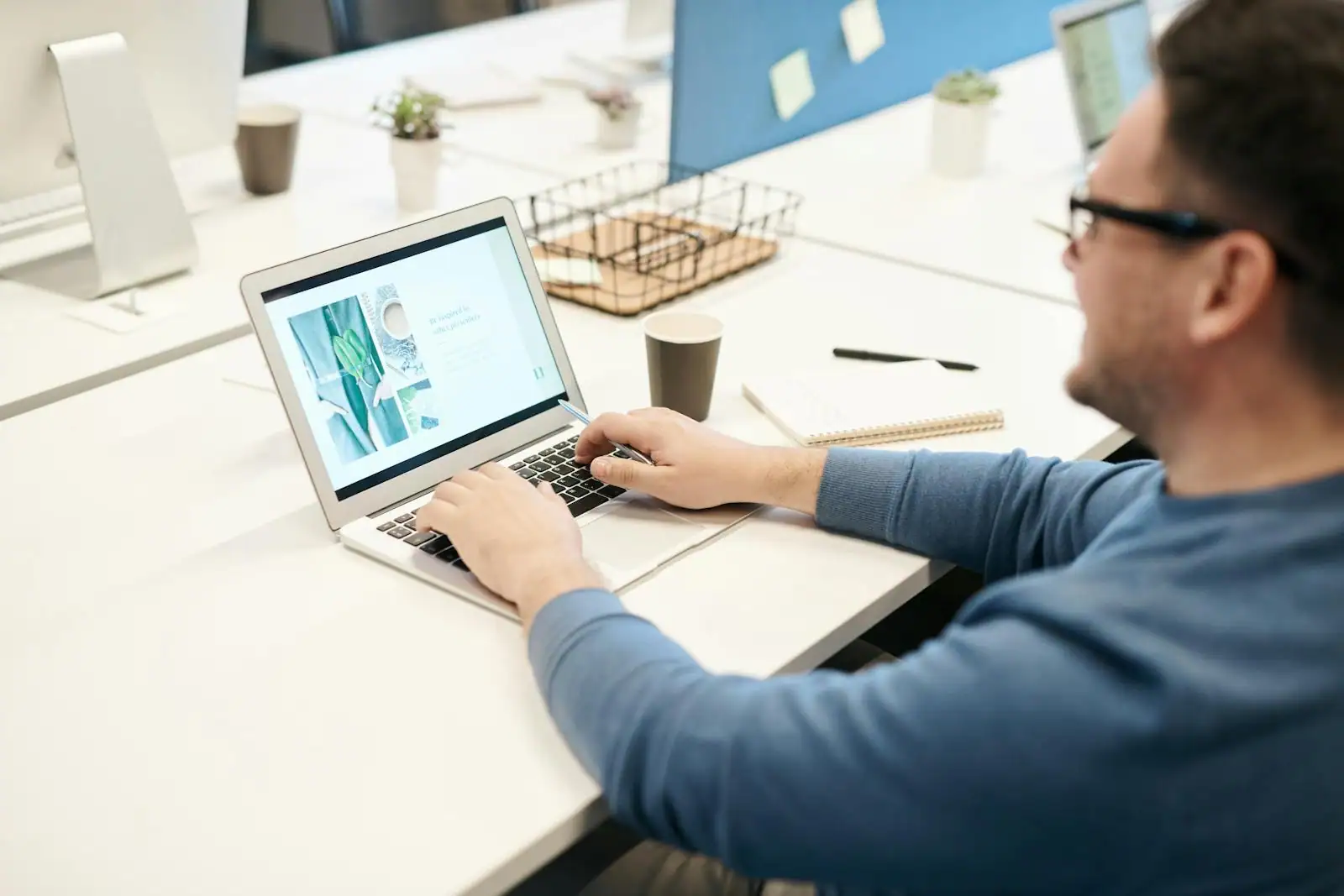 Personne cherchant des offres d'emploi sur un ordinateur portable dans un bureau clair.