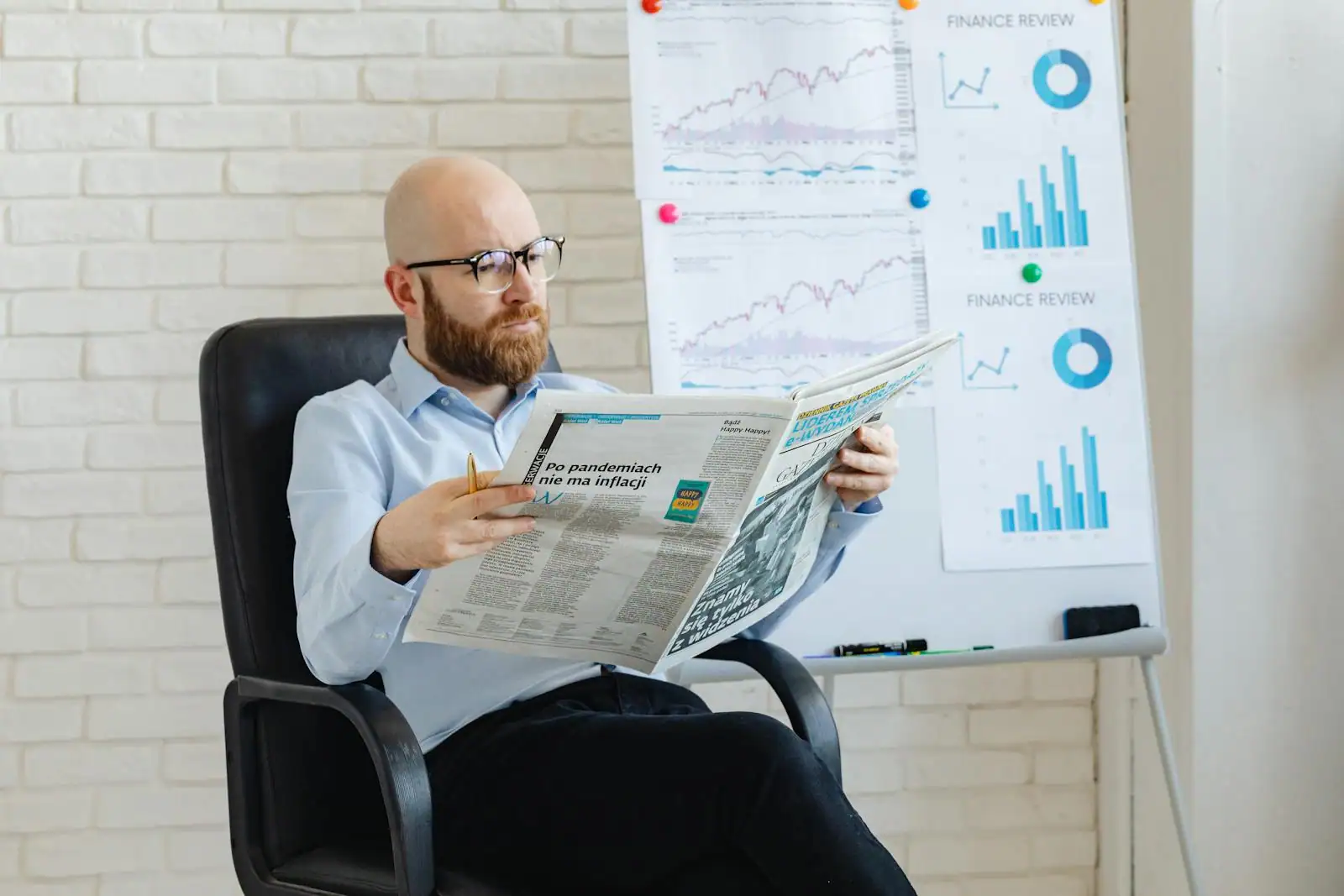 Professionnel consultant l'actualité économique sur un écran d'ordinateur et la presse financière
