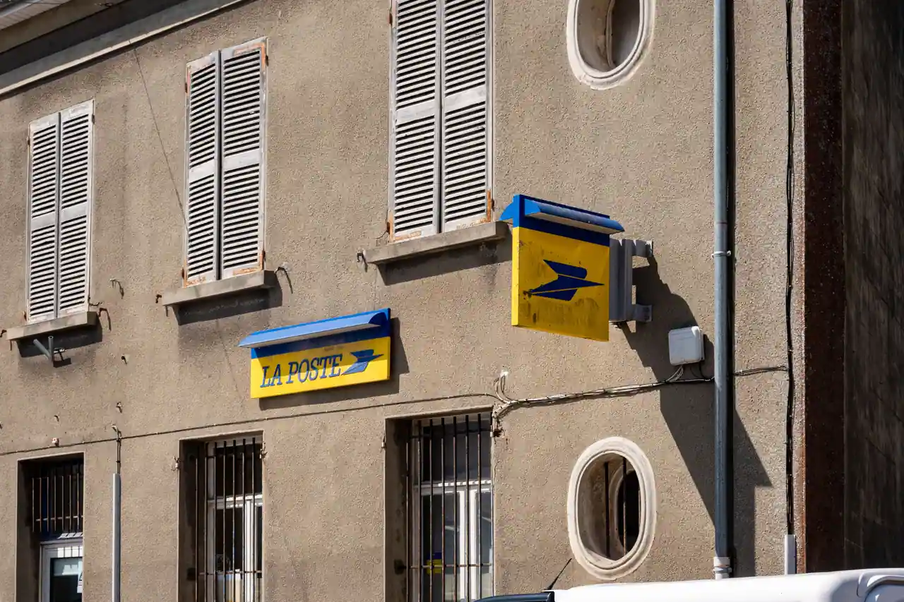 Façade d’un bureau de poste français avec les enseignes jaune et bleu de La Poste.