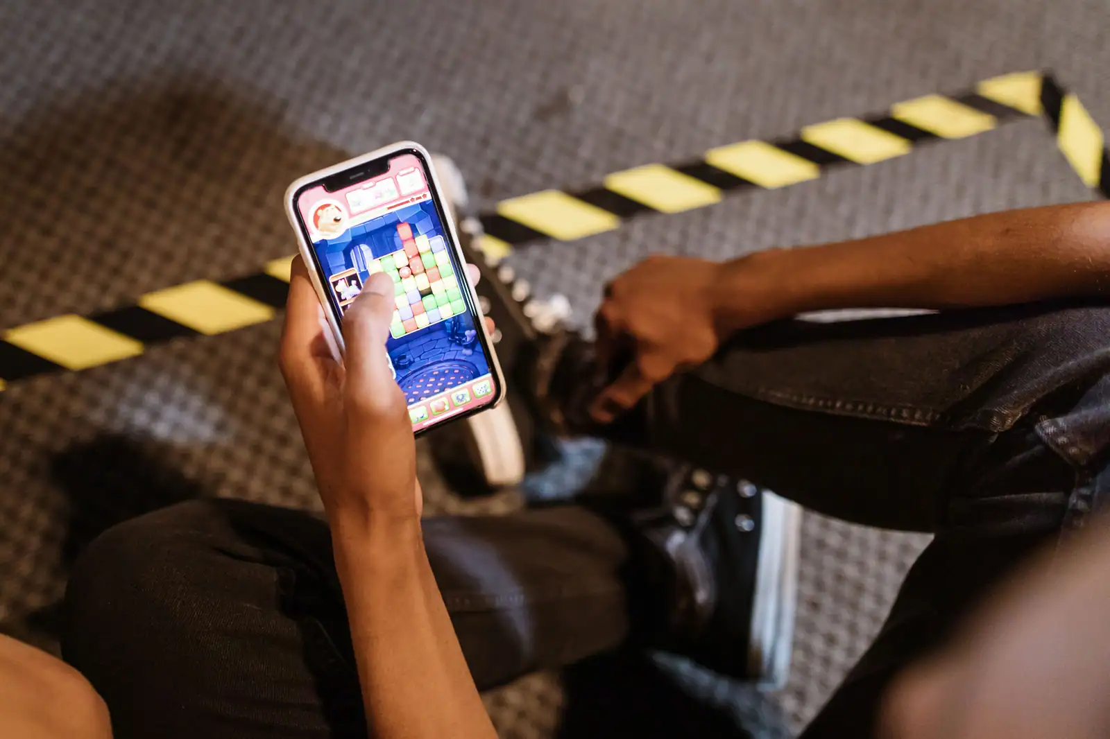 Joueur absorbé par un jeu mobile coloré sur son smartphone, l’univers quotidien des jeux casual.
