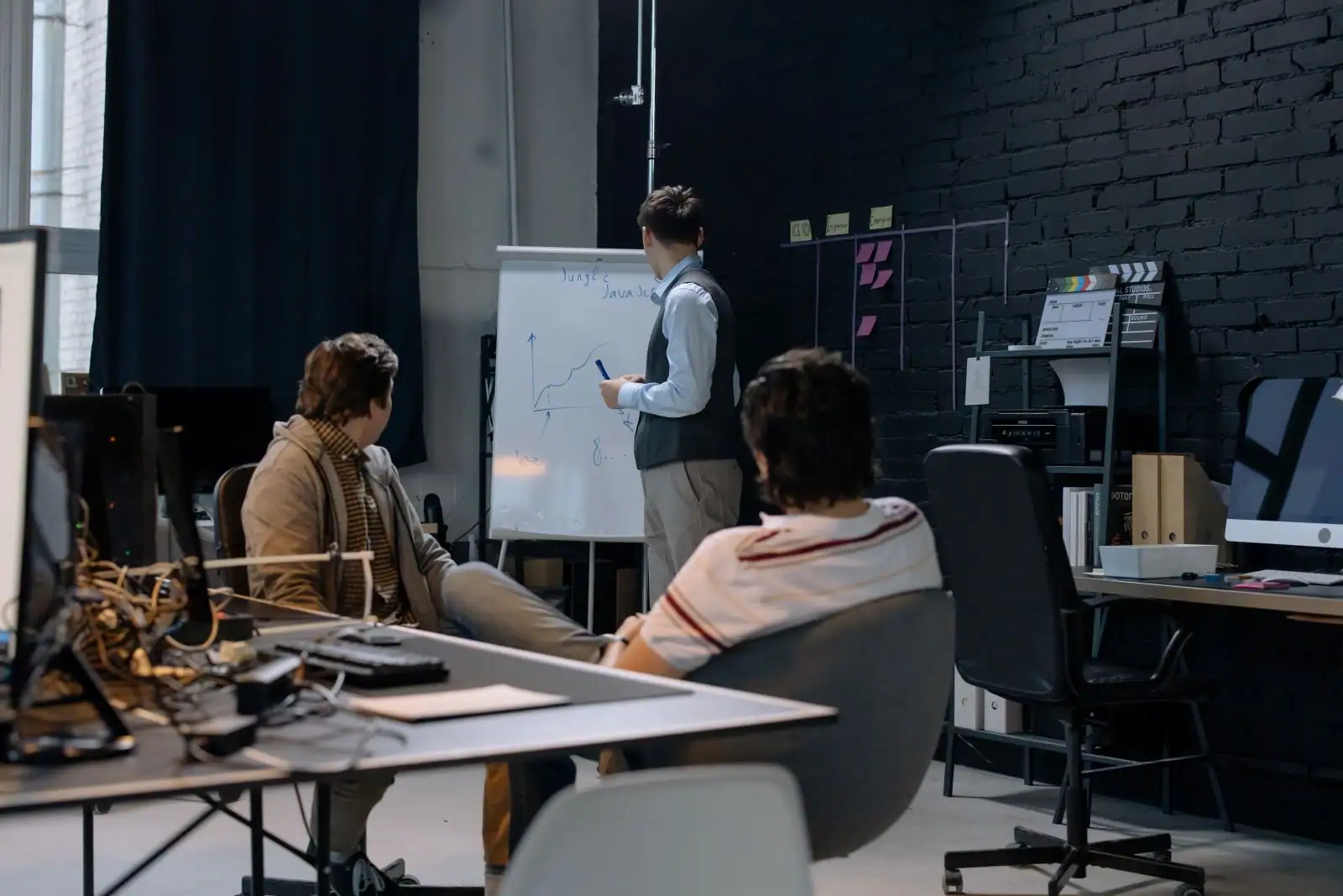 Formateur traçant une courbe de croissance sur un paperboard devant deux participants en atelier