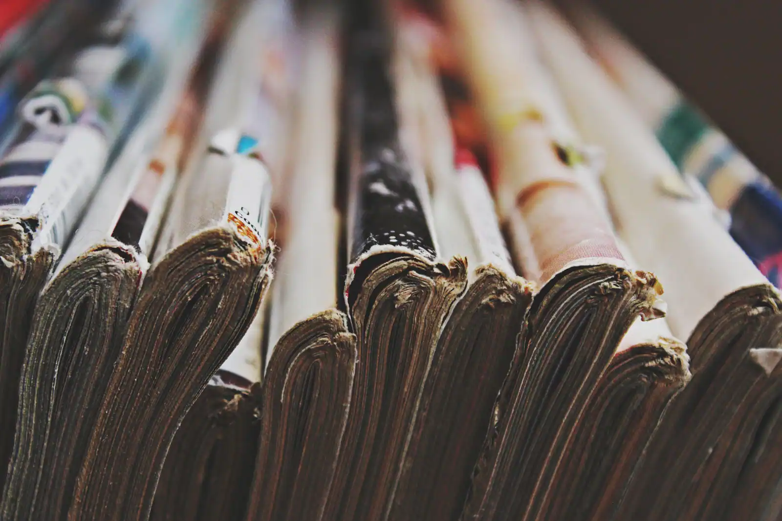 Piles de magazines feuilletés vus sur la tranche, symbole de la presse d’information écrite