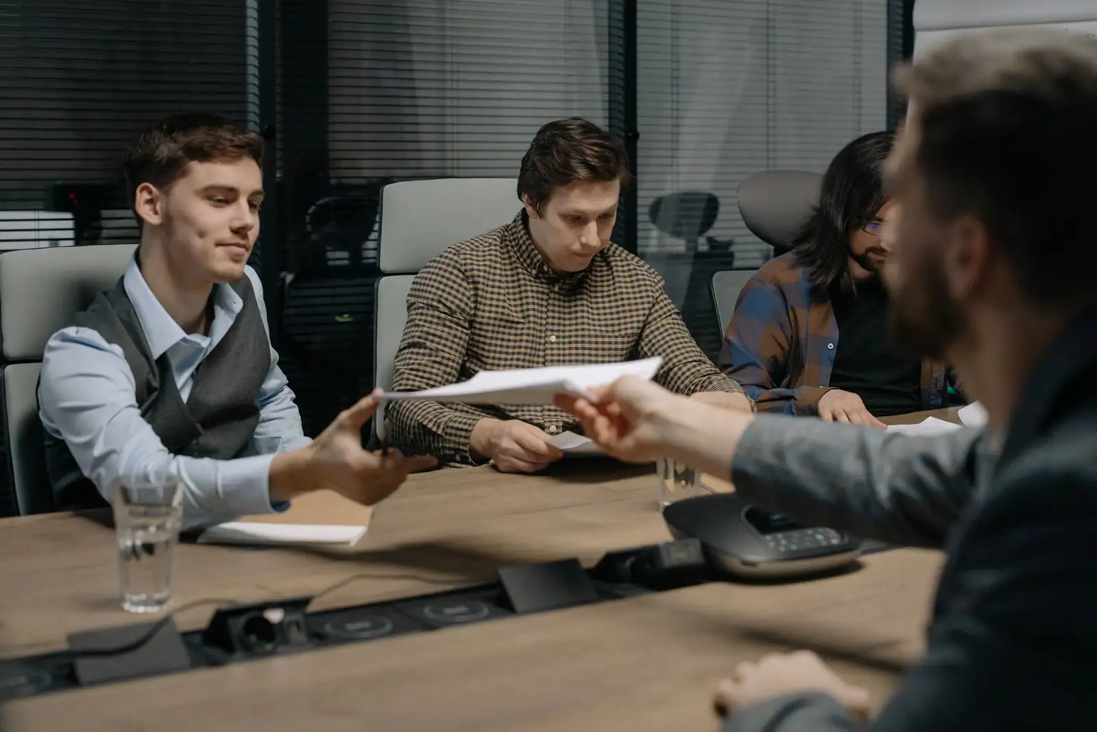 Des membres réunis autour d'une table se transmettent les documents de création de leur association.