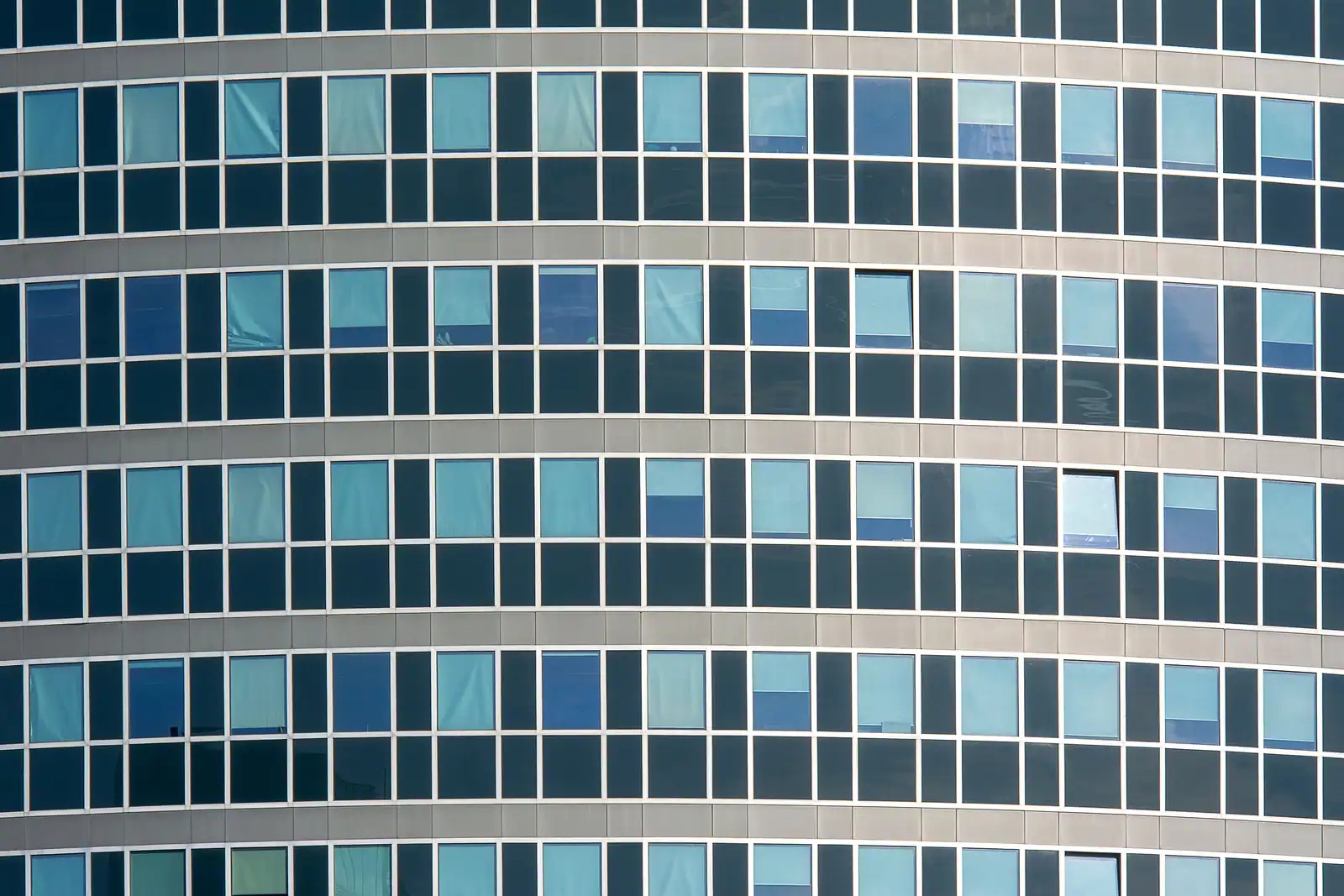 Façade vitrée d'un immeuble de bureaux moderne, symbole de l'activité tertiaire et du conseil