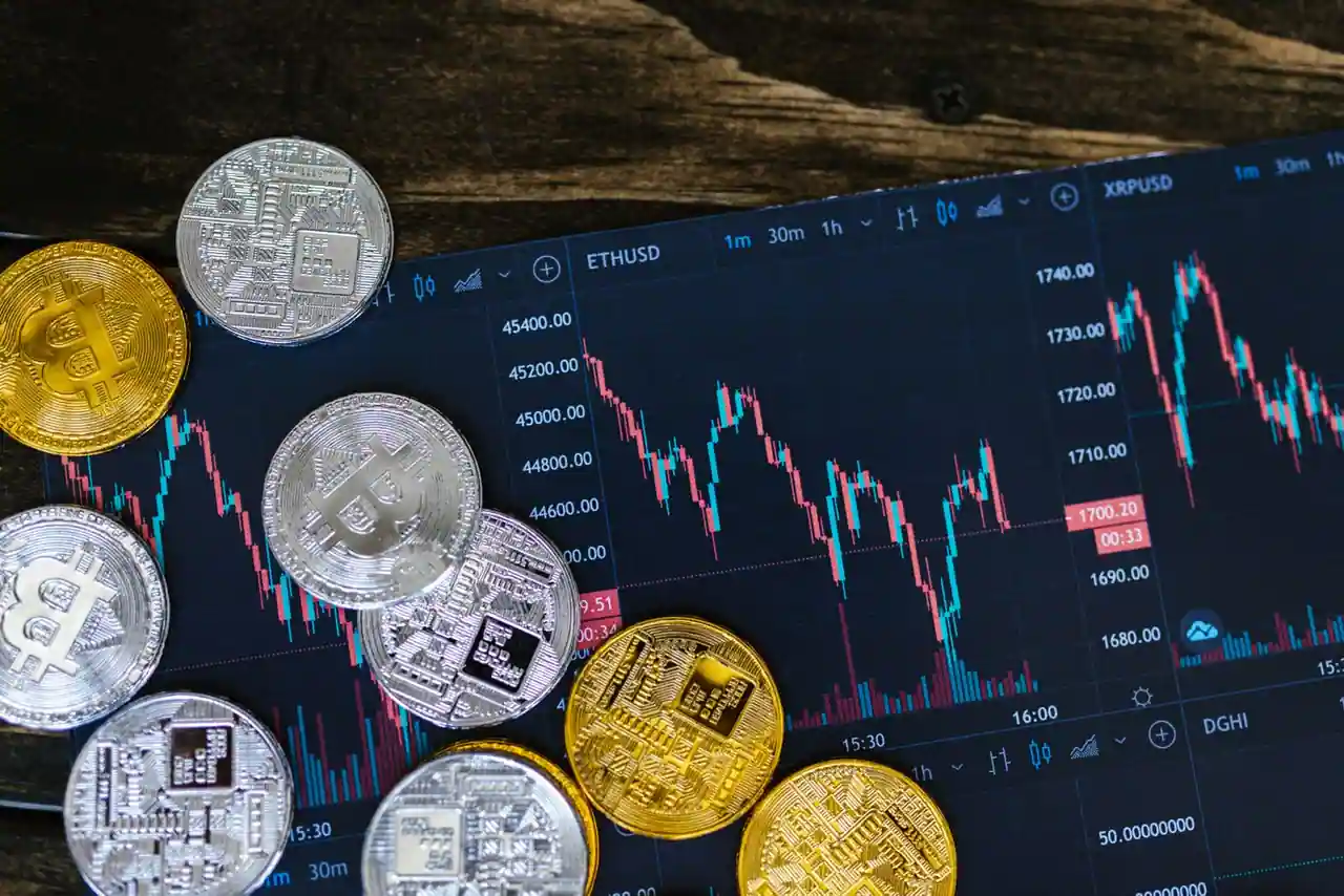 Écran affichant des cours de cryptomonnaies aux côtés de jetons numériques représentant un stablecoin.